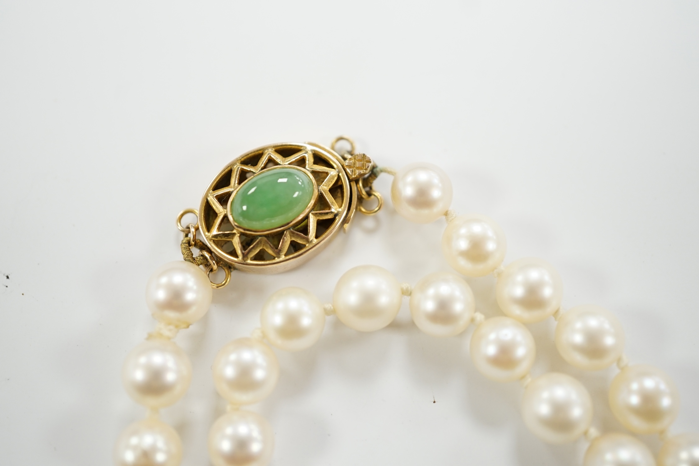 A single strand cultured pearl necklace, with 14k and jade set clasp, 40cm.